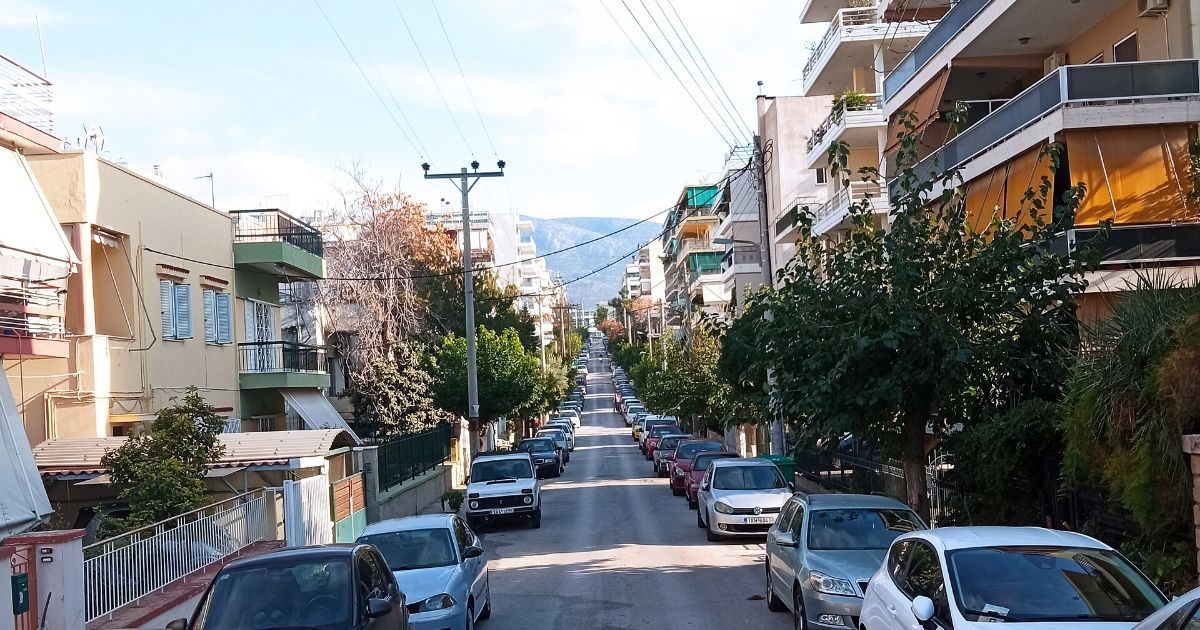 Δρόμος γειτονιάς με πολυκατοικίες και δέντρα στον Άγιο Δημήτριο