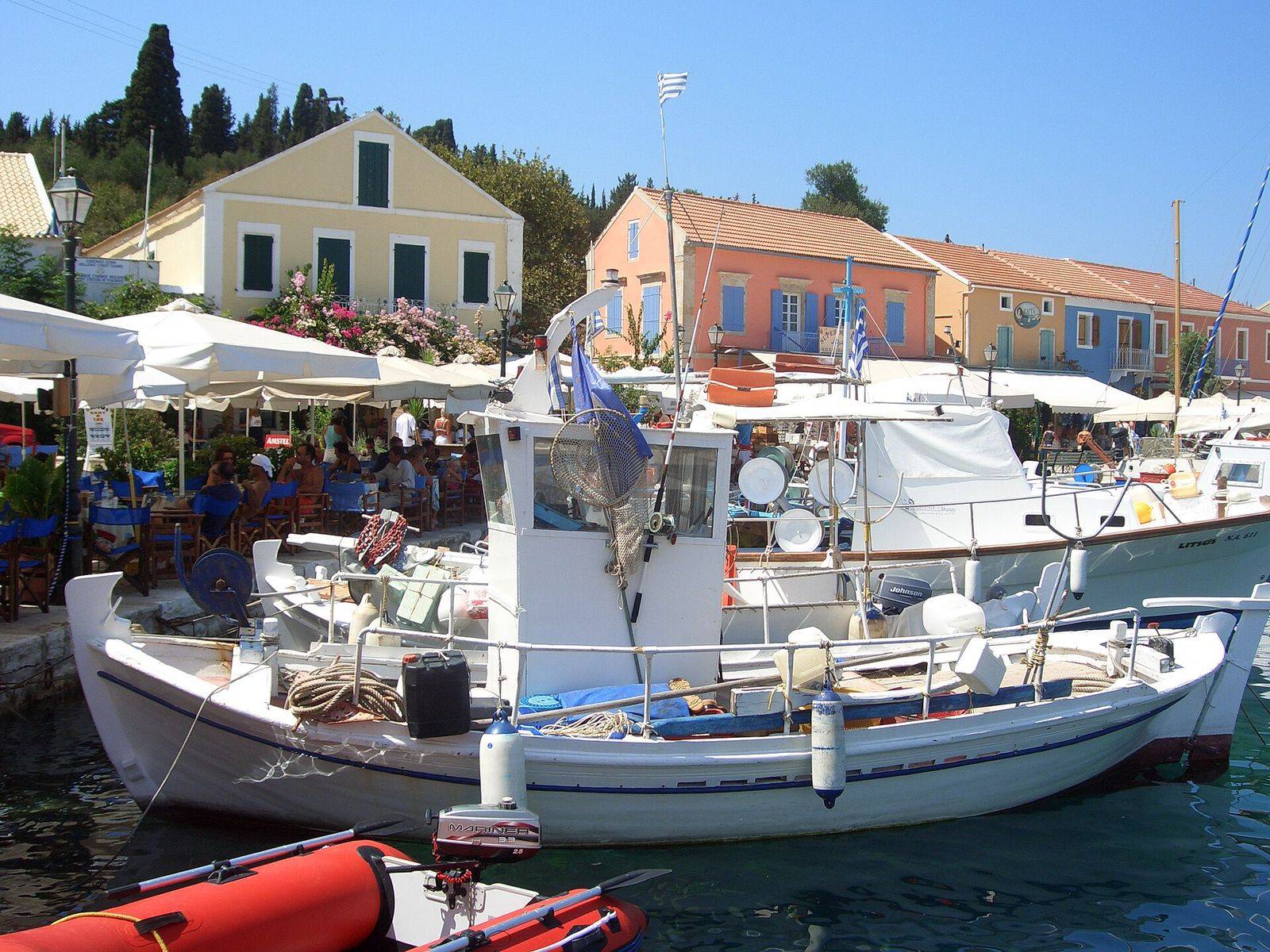 Colourful houses and fishing boats on the harbour of Fiskardo in Kefalonia