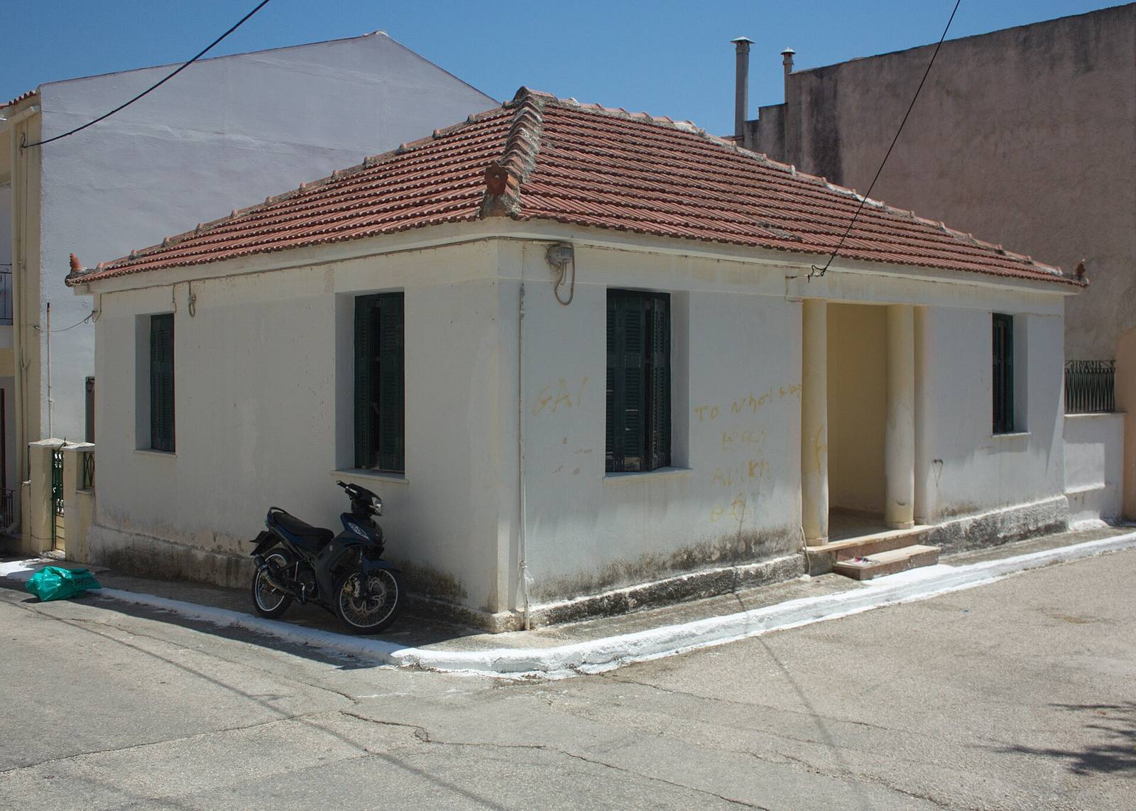 A single-storey white house with a tiled roof in Lixouri, Kefalonia